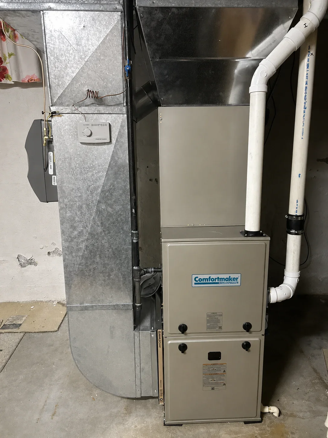Comfortmaker furnace and air handler with white PVC ductwork and thermostat installation